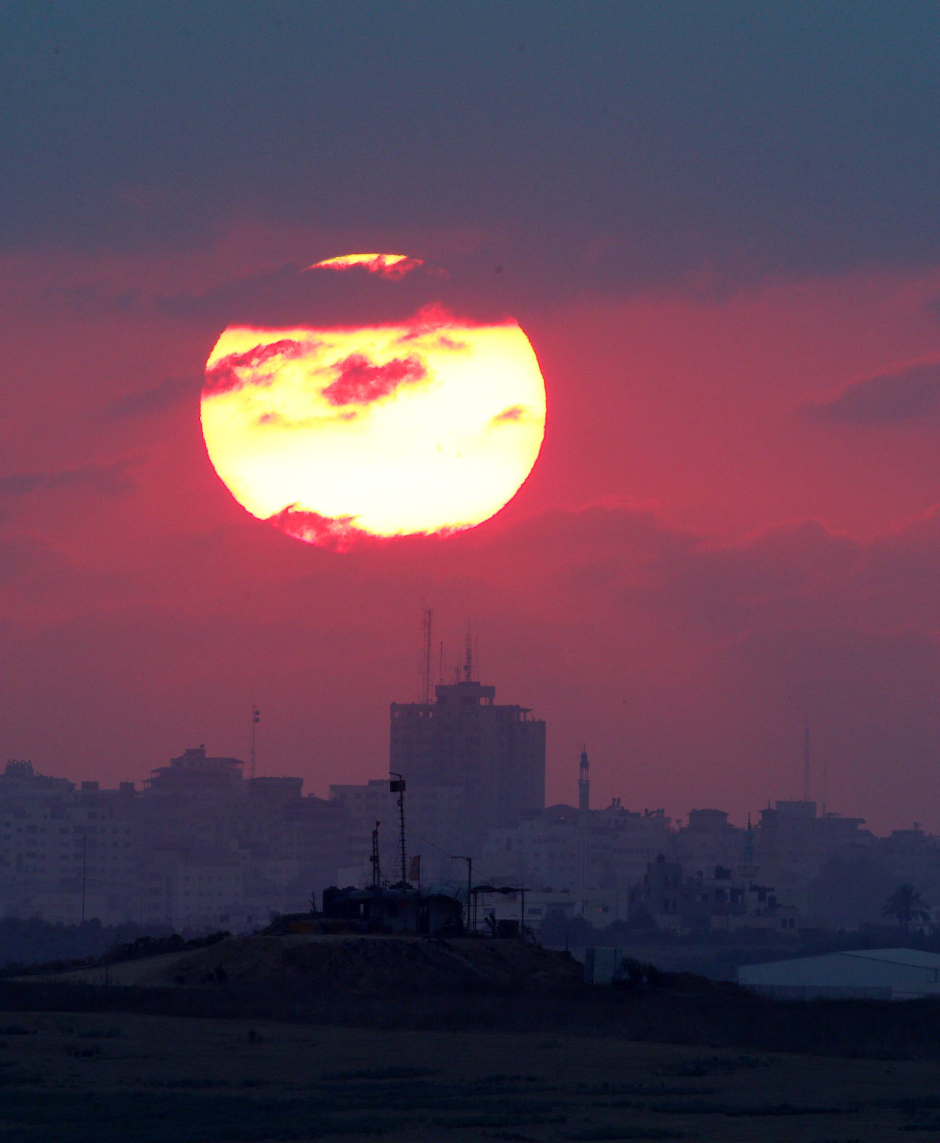 The sun sets over the Gaza Strip, as seen from the Israeli side