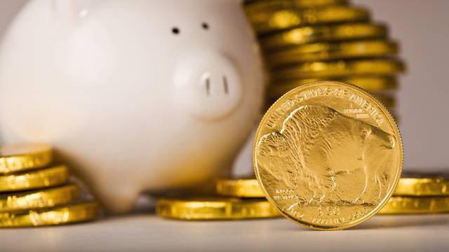 Gold coins savings piled around piggy bank