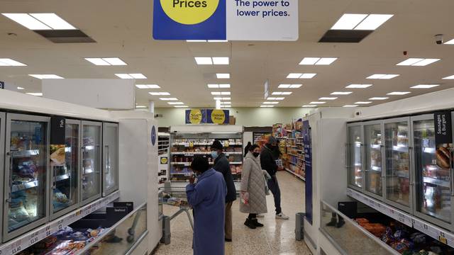 FILE PHOTO: Shoppers are seen inside a branch of a Tesco supermarket in London