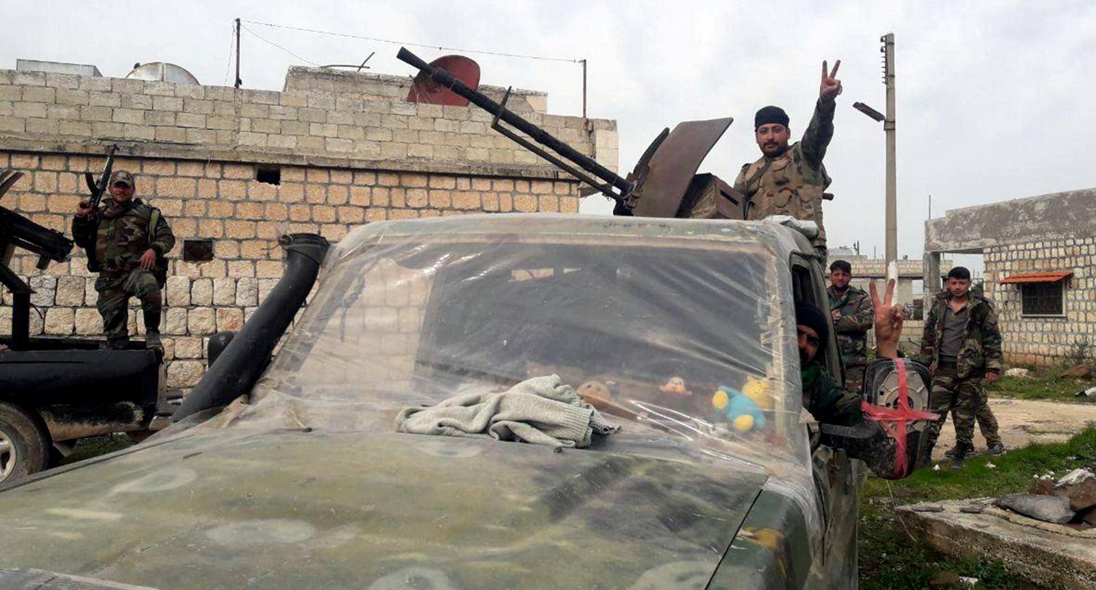 Syrian army soldiers gesture in southern Idlib province