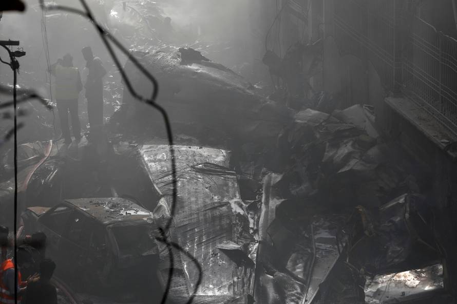 Rescue workers gather at the site of a passenger plane crash in a residential area near an airport in Karachi