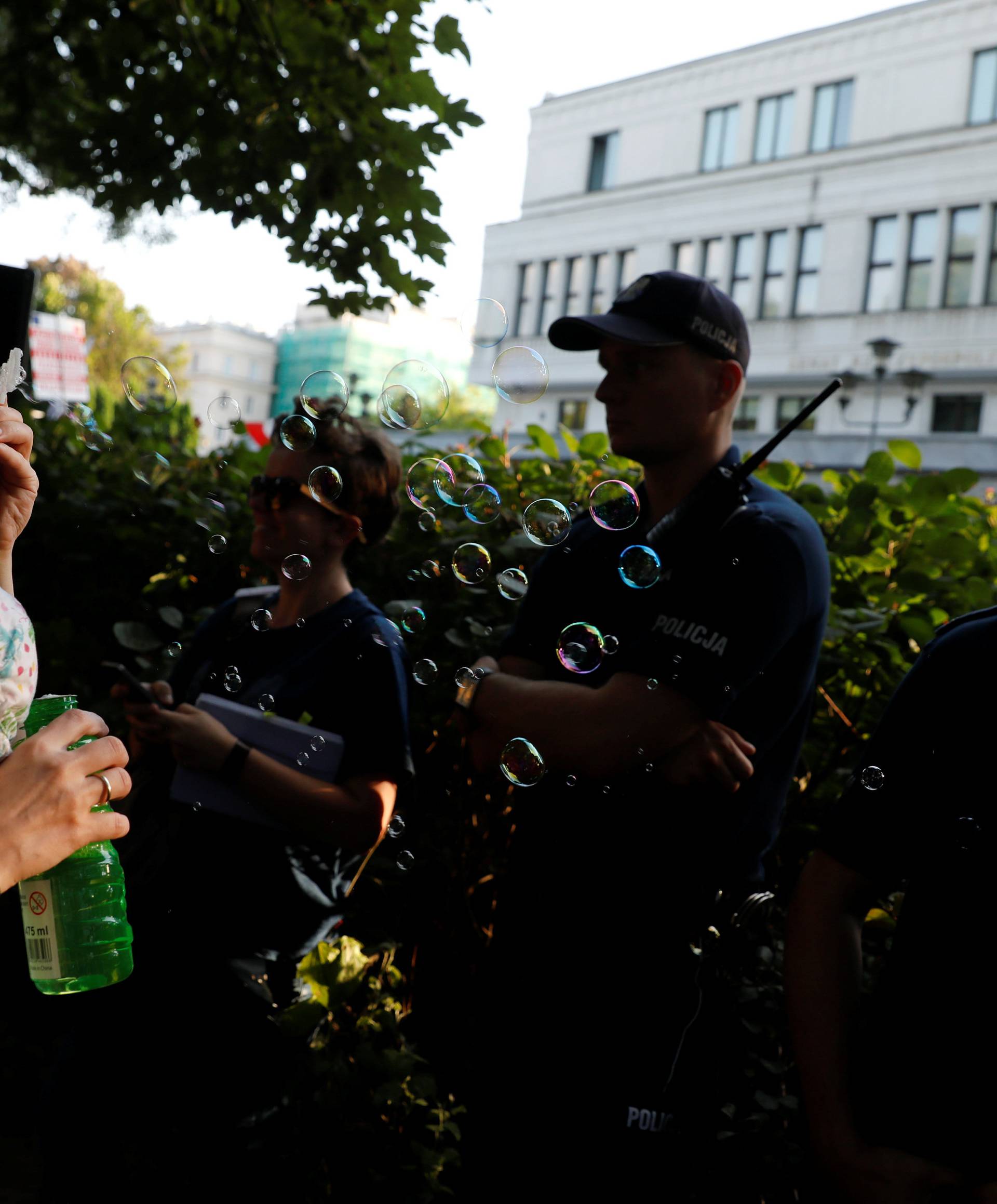 Woman blows soap bubbles during an anti-government protest in support of free courts in front of the the Senate building in Warsaw