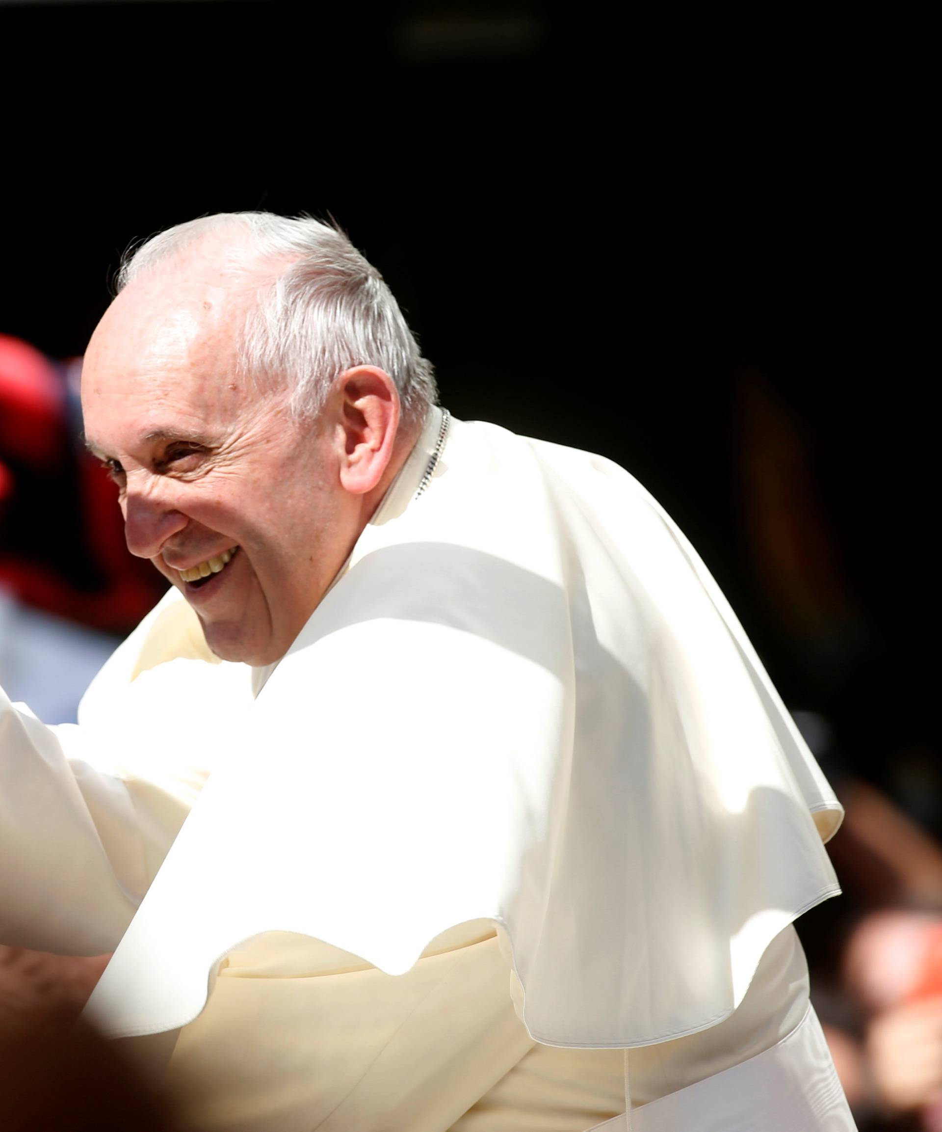 Pope Francis waves as he drives past in Santiago