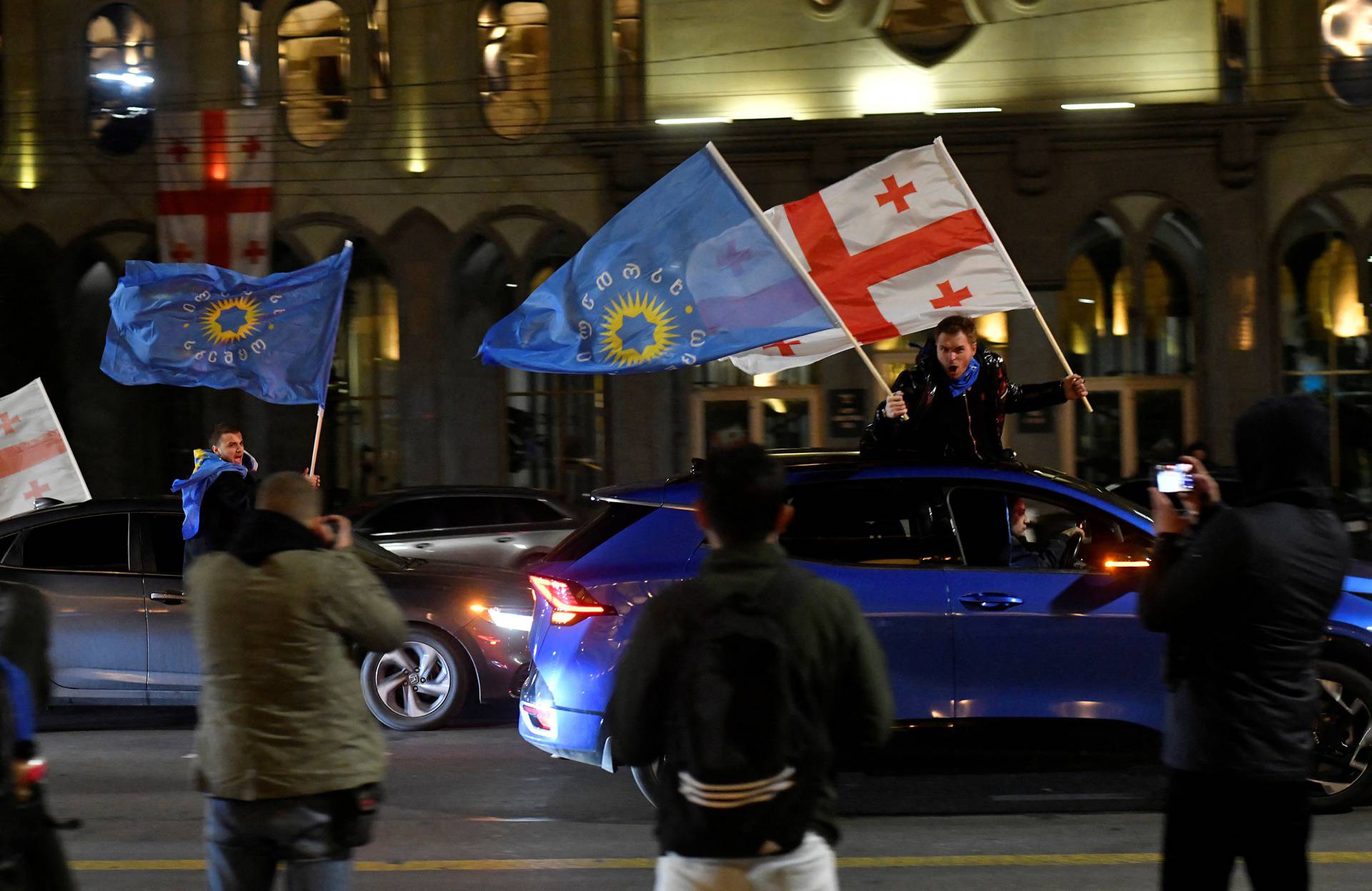 Supporters of the Georgian Dream party celebrate after the announcement of exit poll results in Tbilisi