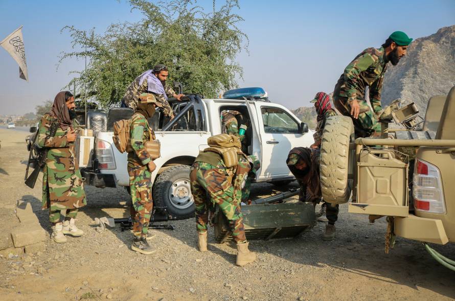 Taliban soldiers load a rocket launcher in a vehicle near Torkham border