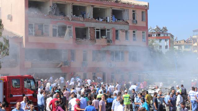 People rush to the blast scene after a car bomb attack on a police station in the eastern Turkish city of Elazig