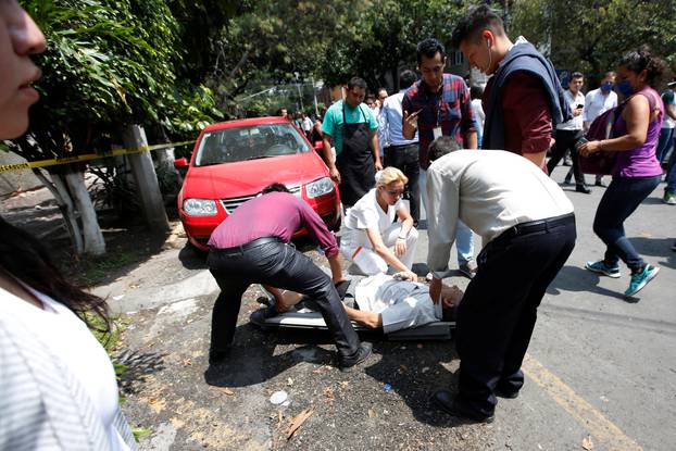 People rescue a man after an earthquake hit Mexico City, Mexico