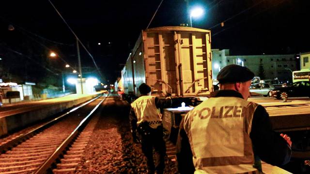 Police officers check a freight train for migrants during a routine check on a train station in Steinach am Brenner