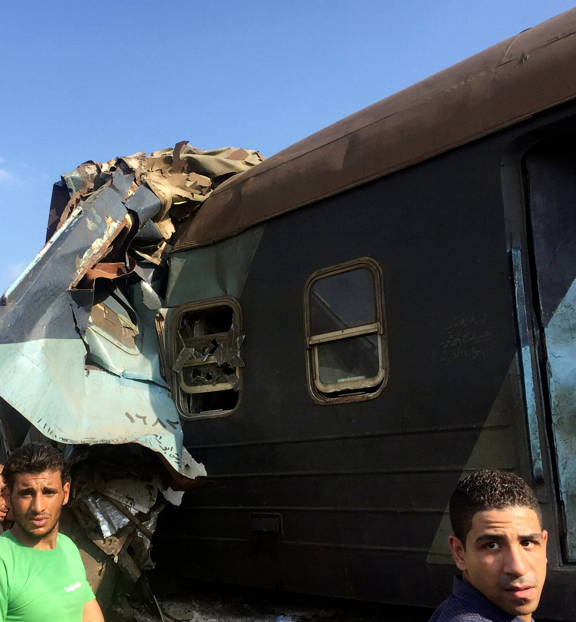 Egyptians look at the crash of two trains that collided near the Khorshid station in Egypt's coastal city of Alexandria
