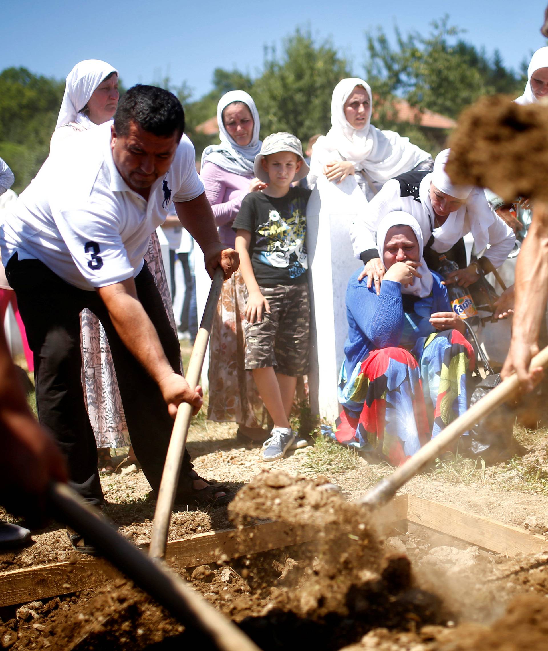 Muslim women cry during mass funeral in Potocari near Srebrenica