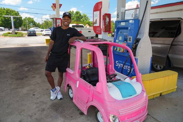 Mali Hightower poses with a pink Power Wheels Barbie Dream Camper outside a gas station in Ellenwood