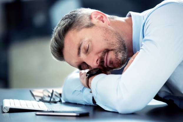 Businessman, tired and sleeping with desk in office with exhausted from overworked in company. Corporate, closeup and burnout from stress in financial analyst job with fatigue, break and low energy