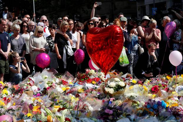 People observe a minute of silence for the victims of the Manchester Arena attack in central Manchester