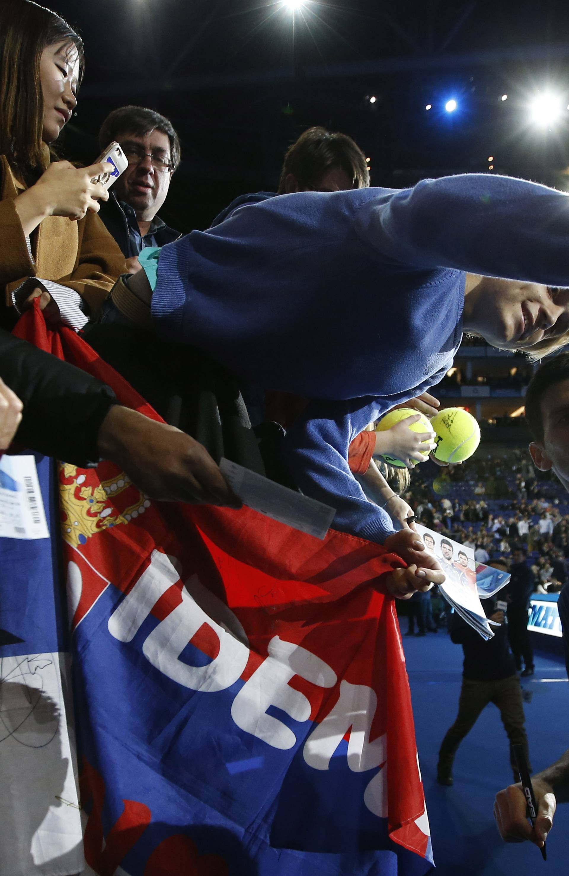 Serbia's Novak Djokovic poses for a selfie with spectators after winning his round robin match with Belgium's David Goffin