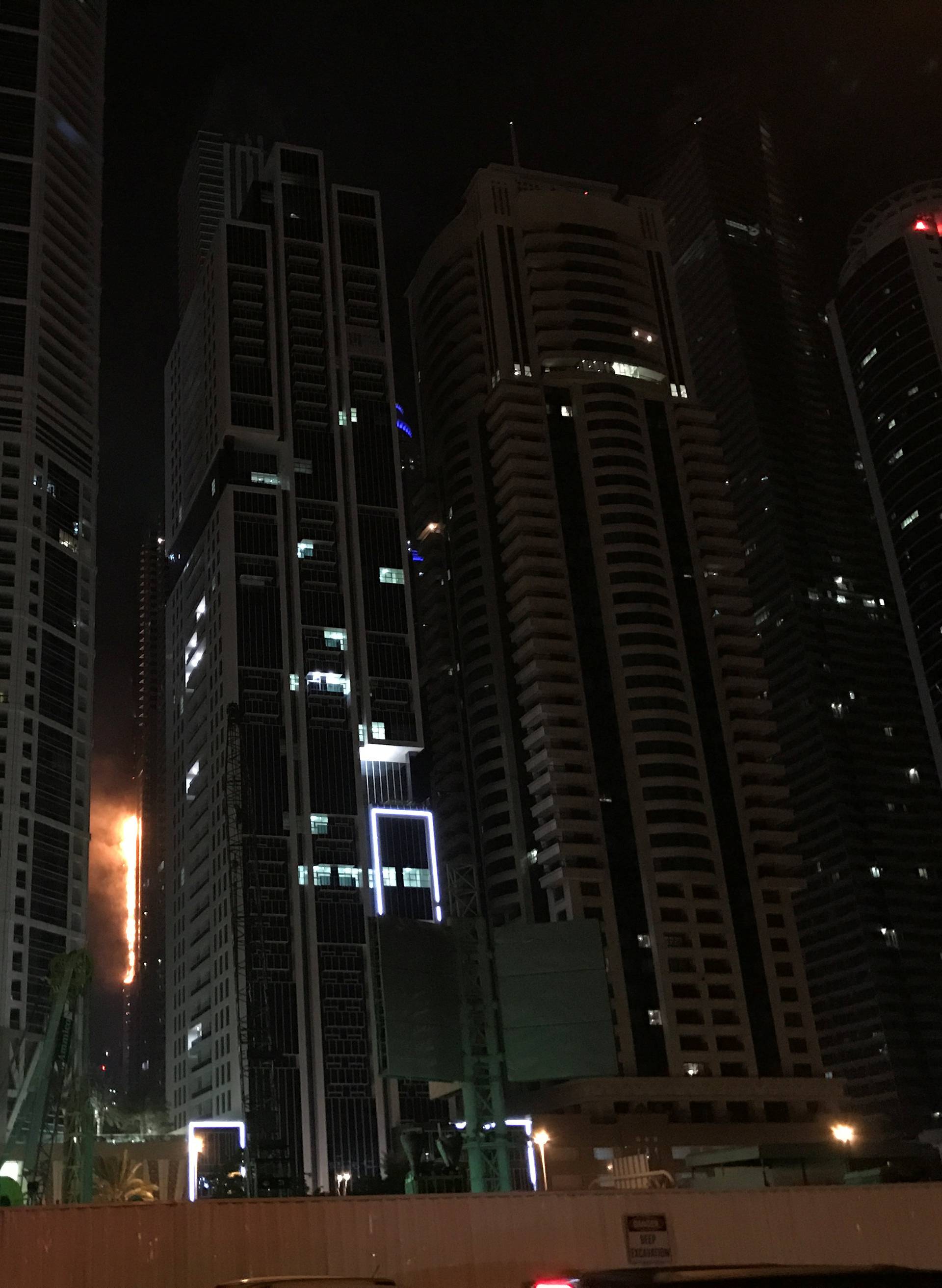 Flames shoot up the side of the Torch tower residential building in the Marina district, Dubai