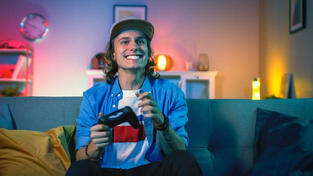 Handsome,Excited,Young,Gamer,With,Long,Hair,And,A,Cap