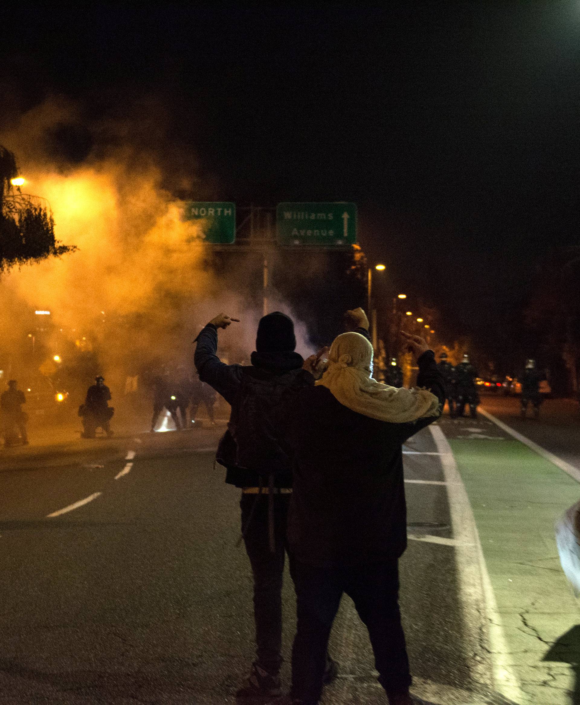 Marchers approach a freeway onramp guarded by police during a protest against the election of Republican Donald Trump as President of the United States in Portland, Oregon