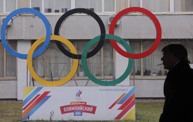 FILE PHOTO: A man smokes near Olympic rings placed in the courtyard of the Russian Olympic Committee headquarters in Moscow