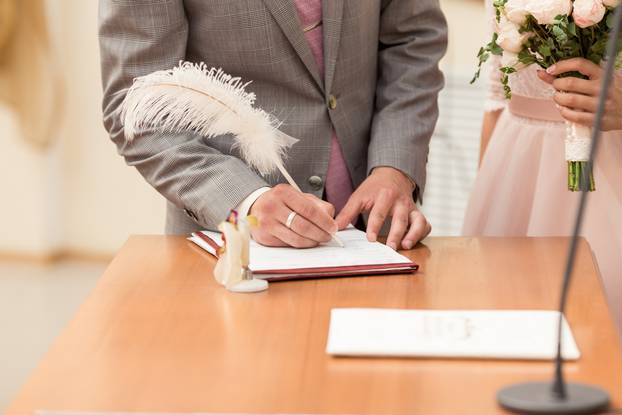 Bride and bridegroom signing the marriage contract after the wedding ceremony