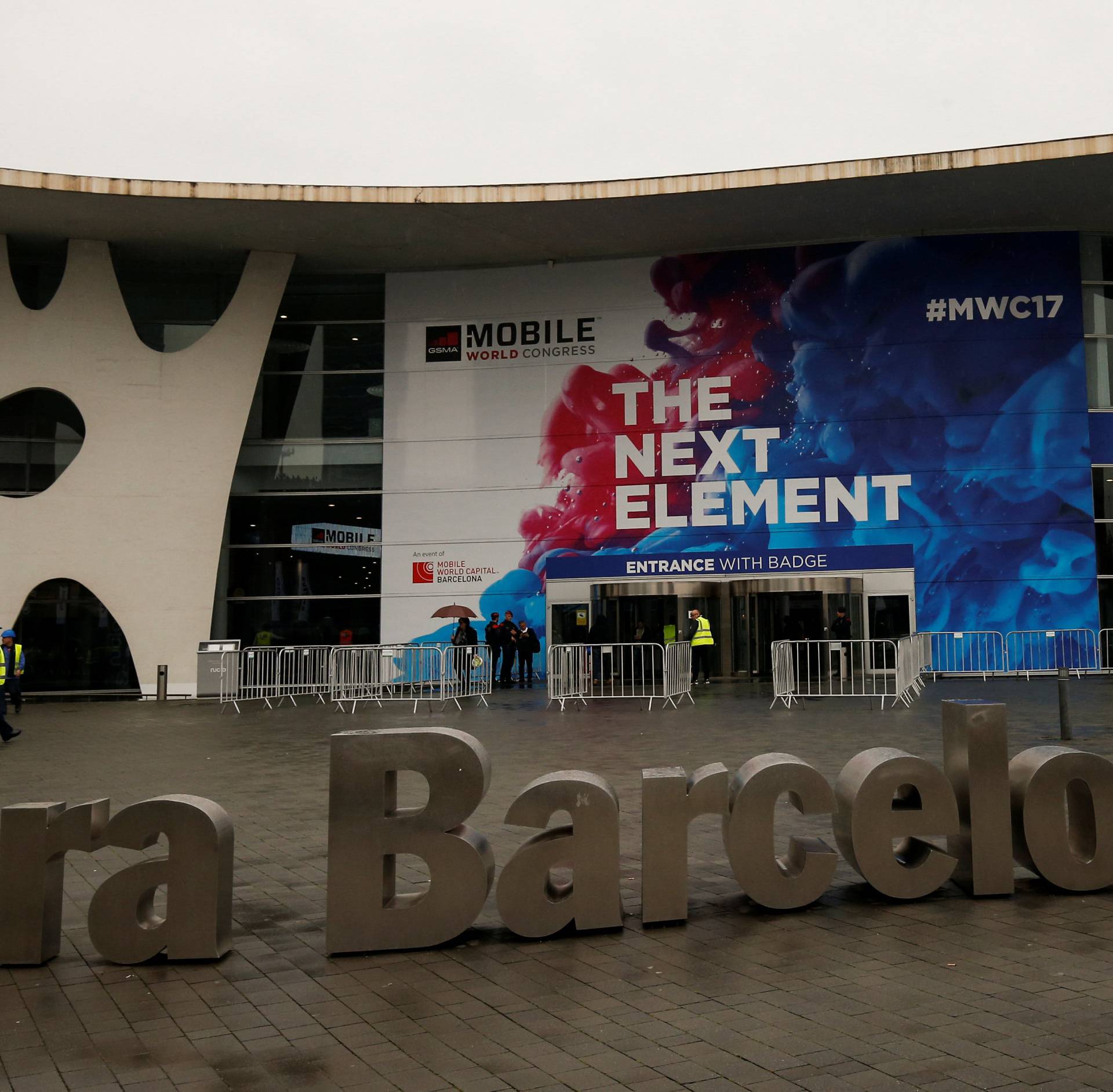 Workers walk past the main entrance of the Mobile World Congress in Barcelona