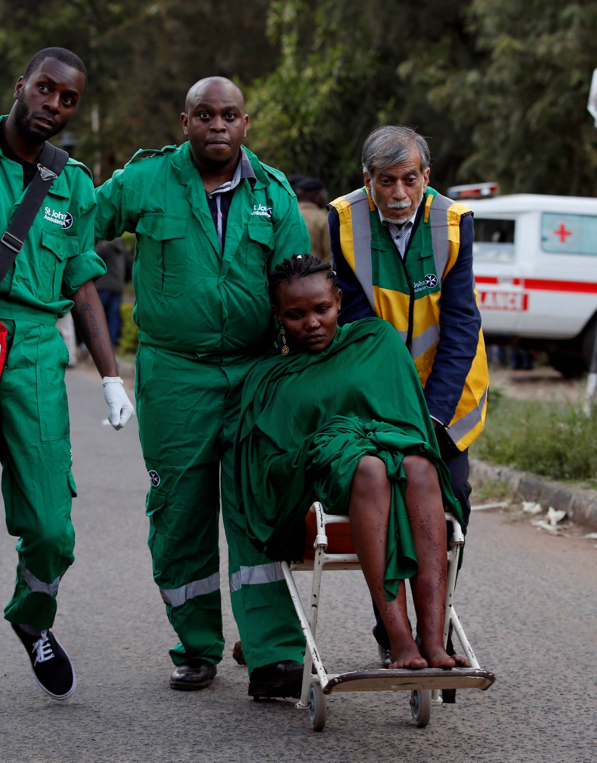 An injured woman is evacuated from the scene where explosions and gunshots were heard at the Dusit hotel compound, in Nairobi