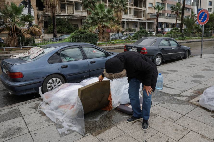 A displaced man sits on a bench at the corniche in Beirut after rainfall