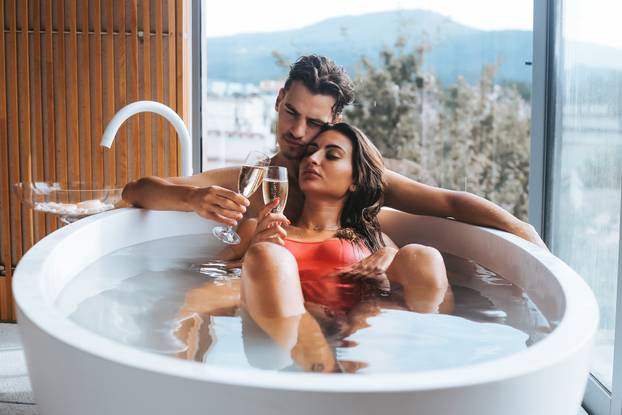 Couple enjoying a bath with champagne