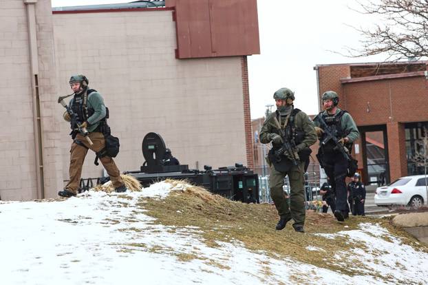 Law enforcement officers sweep the area outside of a King Soopers grocery store, which was the site of a shooting in Boulder