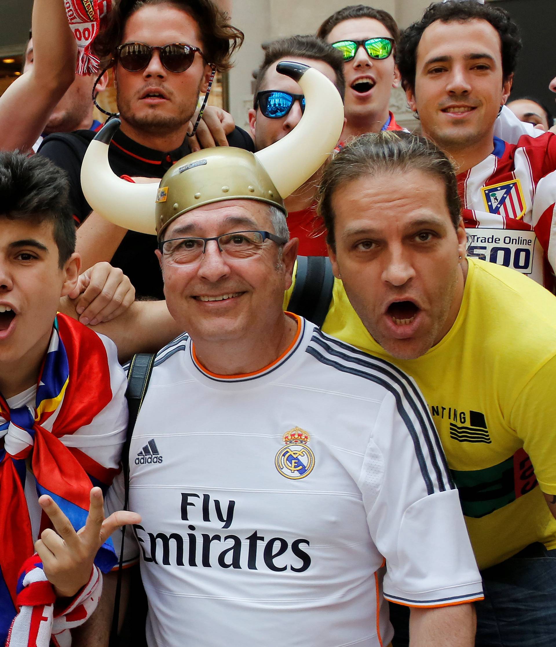 A Real Madrid fan poses with Atletico Madrid fans before the Champions League Final between Real Madrid and Atletico Madrid in Milan