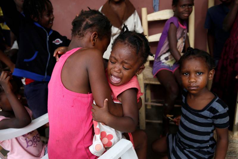 A girl cries as she stays with her relatives at a partially destroyed school after Hurricane Matthew passes Jeremie, Haiti