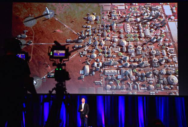Elon Musk, founder and Chief Executive Officer and lead designer of SpaceX, reacts as a screen displays a depiction of a human colony on the planet Mars during a presentation at the International Astronautical Congress in Adelaide