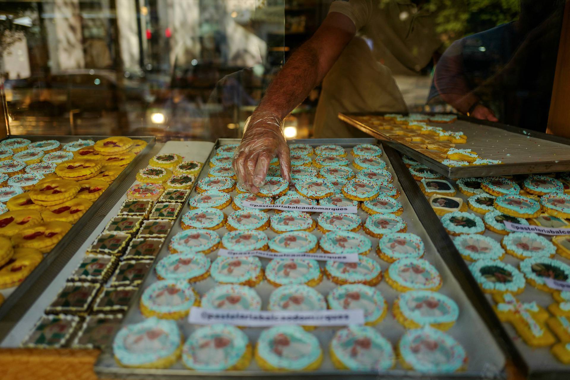 A person puts cookies with Pope Francis images in a bakery storefront ahead of his apostolic journey to Portugal, in Lisbon