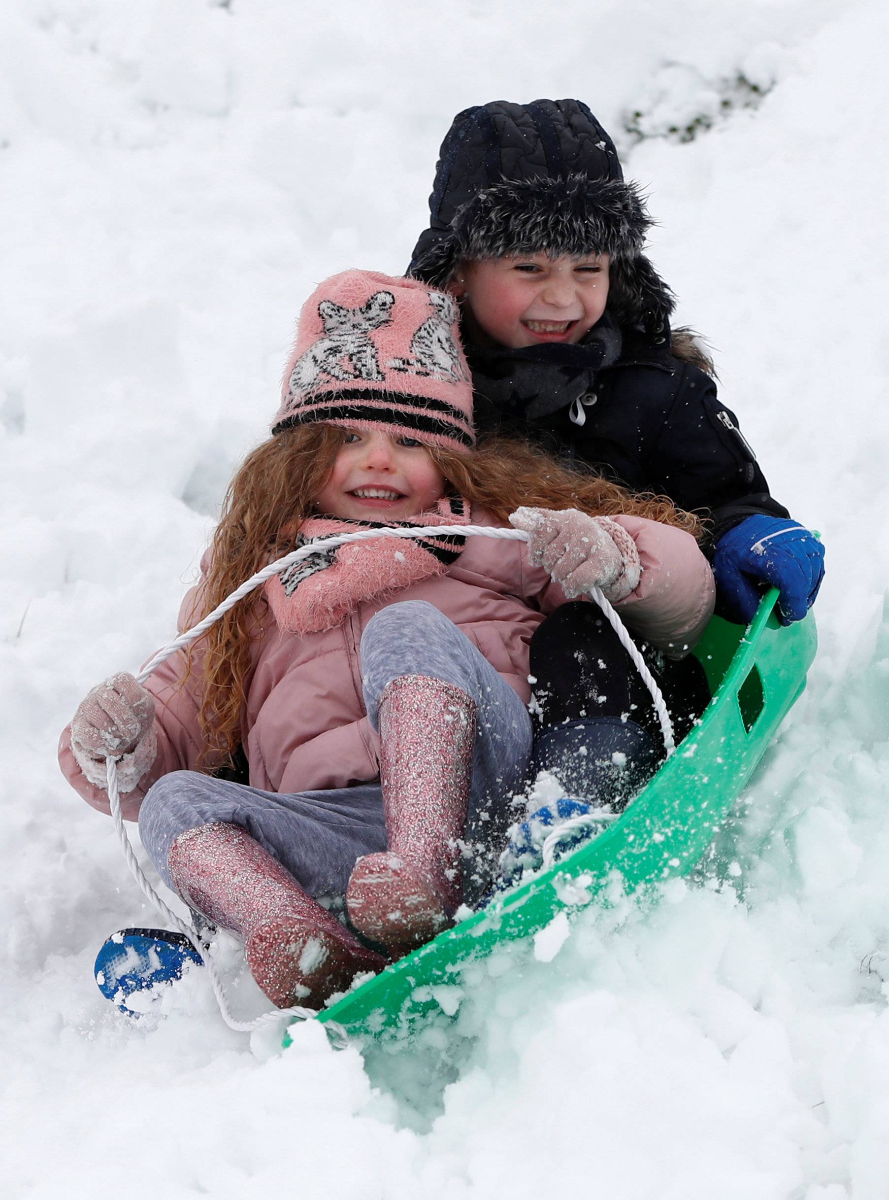 Molly and her brother Riley Stevenson sledge in the snow in Leverstock Green, Hertforshire