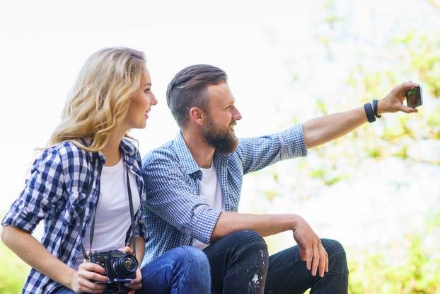 Young loving couple making selfie photo outdoor.