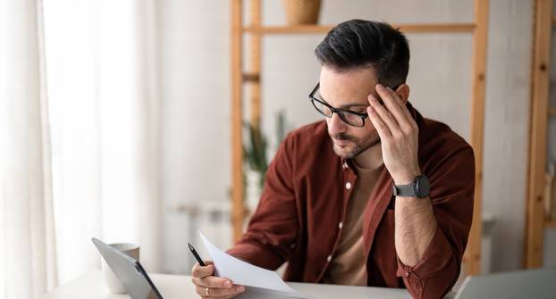Contemplating,Businessman,In,Home,Office,Concentrated,On,Paperwork,Suffering,From