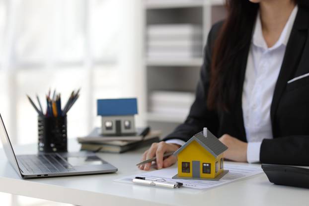 Businesswoman,,Real,Estate,Agent,Presenting,A,House,For,Sale,And