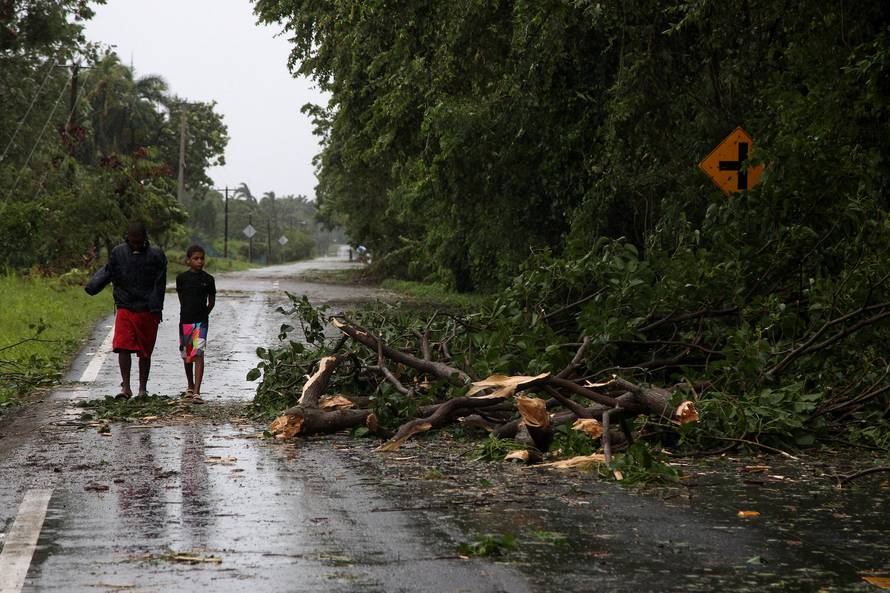 Children walk along a street next to a fallen tree as Hurricane Irma moves off the northern coast of the Dominican Republic, in Nagua