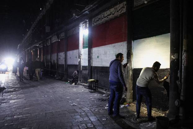A man paints a shutter in Damascus