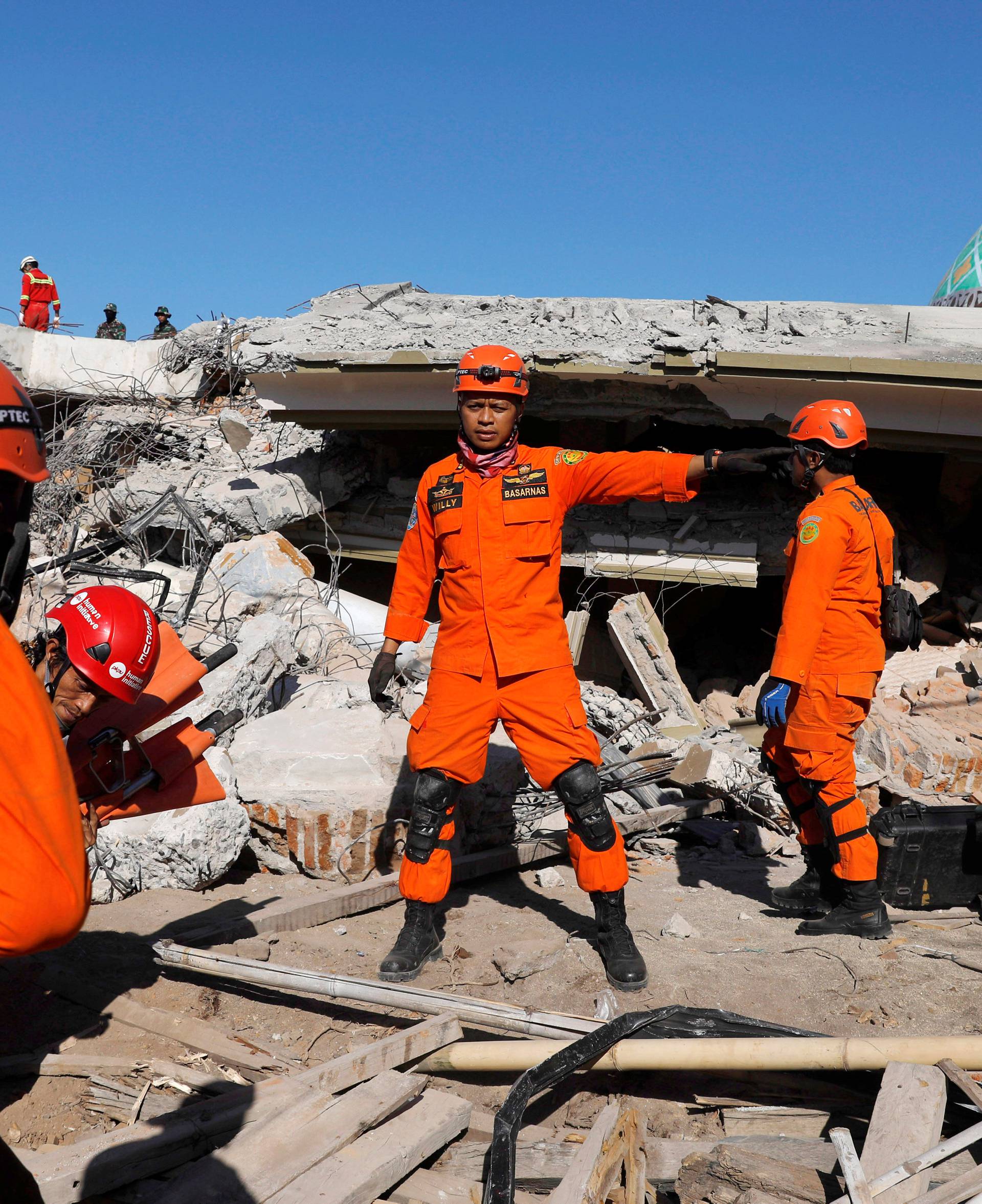 Rescue team members prepare to find people trapped inside a mosque after an earthquake hit on Sunday in Pemenang