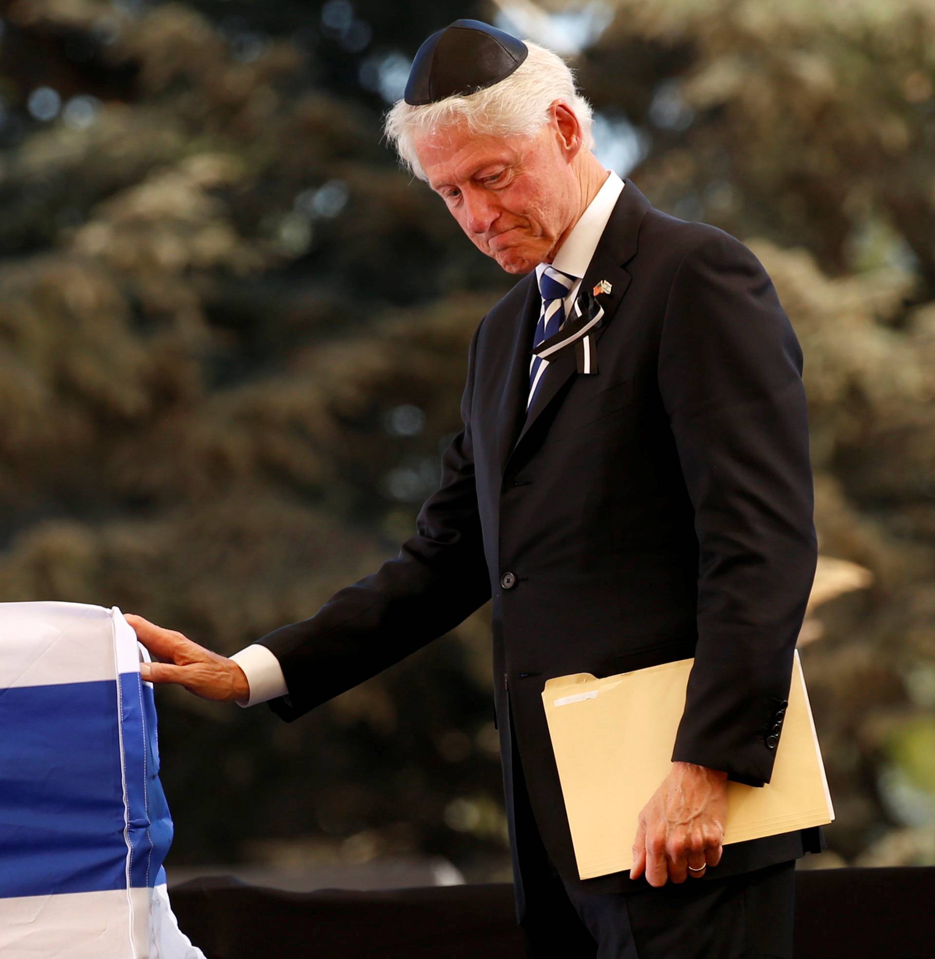 Former US President Bill Clinton stands in front of the flag-draped coffin of the former Israeli President Shimon Peres, during the funeral ceremony at Mount Herzl cemetery in Jerusalem 