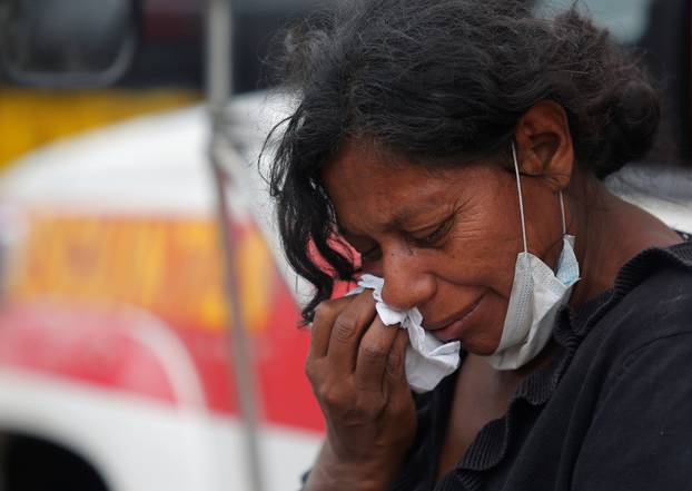 A woman mourns for her missing relatives at an area affected by eruption from Fuego volcano in Escuintla