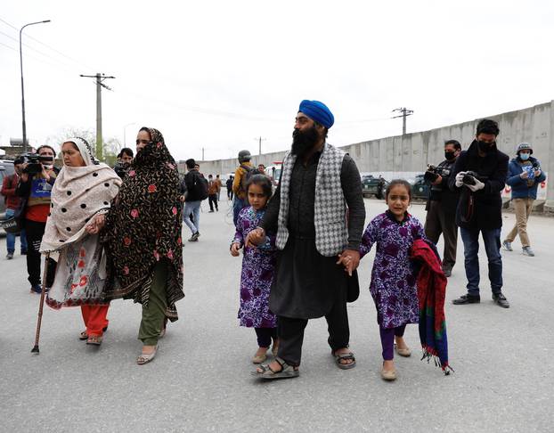 An Afghan Sikh family arrive to see their relatives near the site of an attack in Kabul