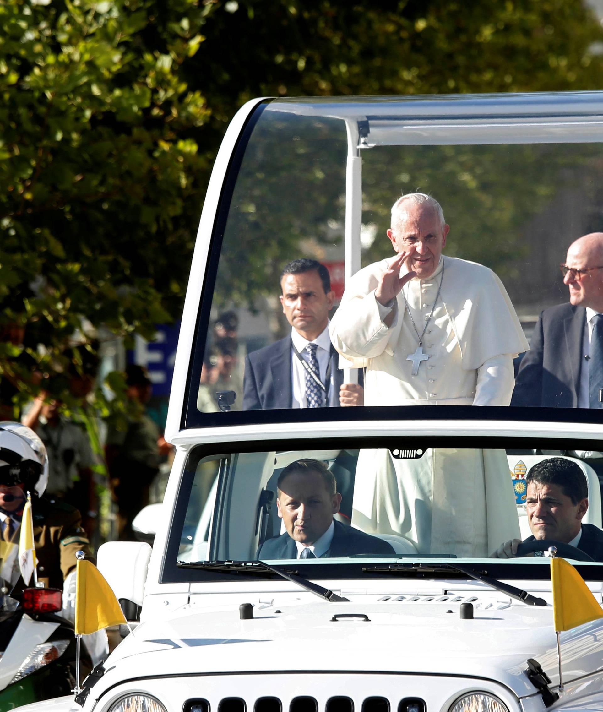 Pope Francis waves while driving through Santiago