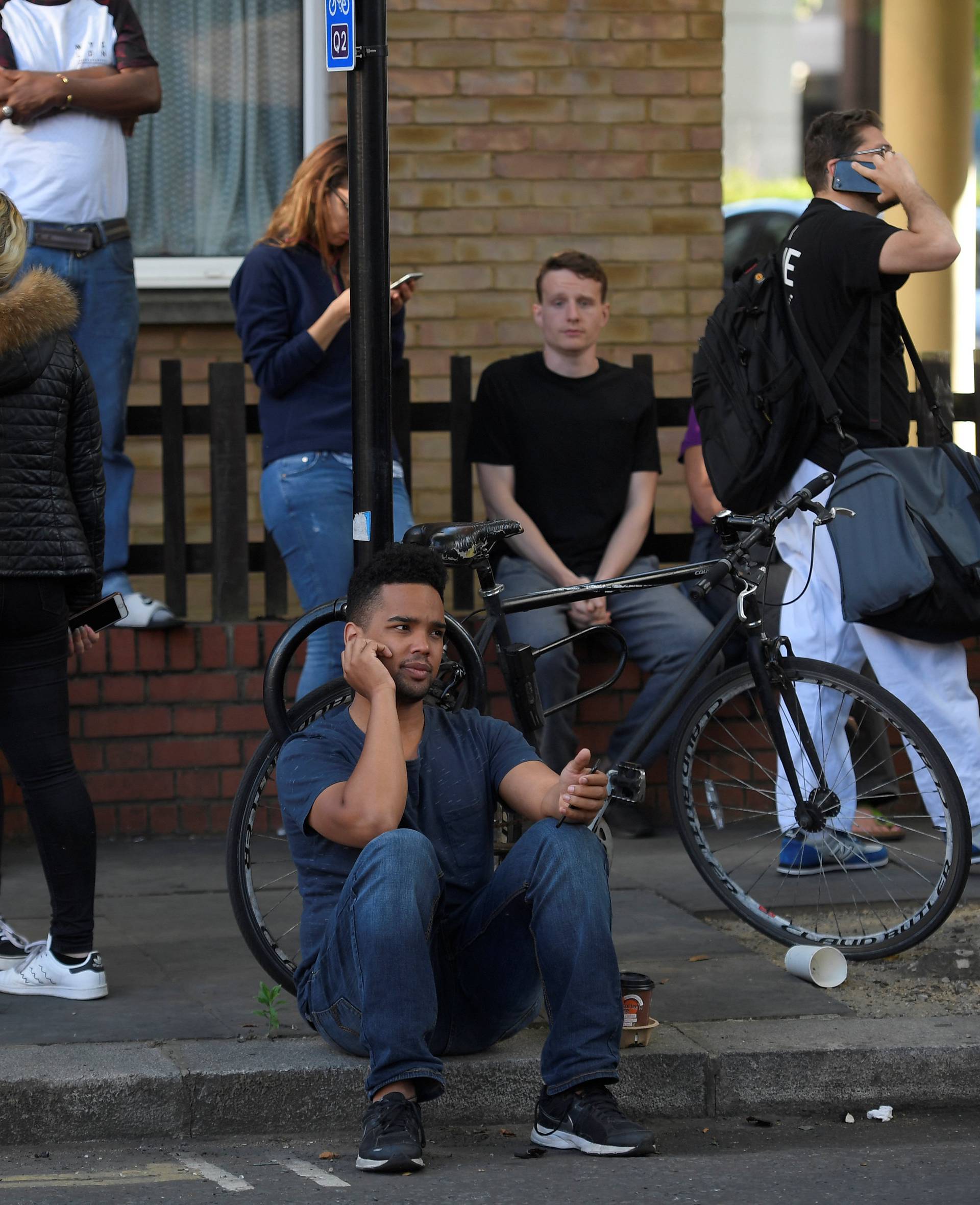 Local residents gather close to the scene of a serious fire in a tower block at Latimer Road in West London