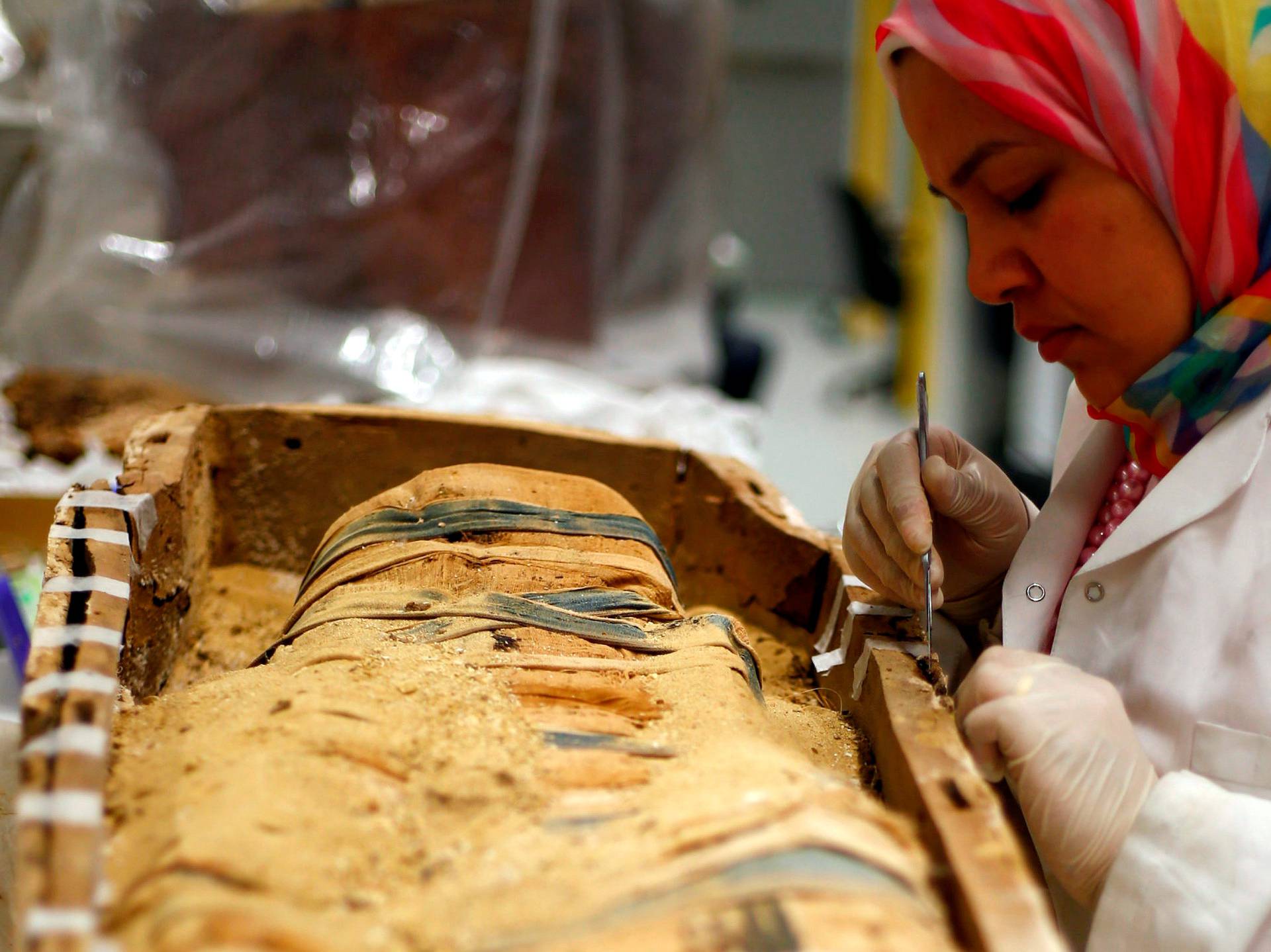 An Egyptian archaeological technician renovates one of the mummies which belonged to The Golden King Tutankhamun, in the conservation centre of the Grand Egyptian Museum, on the outskirts of Cairo
