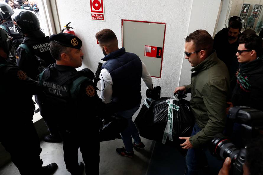 Spanish Civil Guard officers carry confiscated electoral material as they walk out from a polling station for the banned independence referendum where Catalan President Carles Puigdemont was supposed to vote in Sant Julia de Ramis