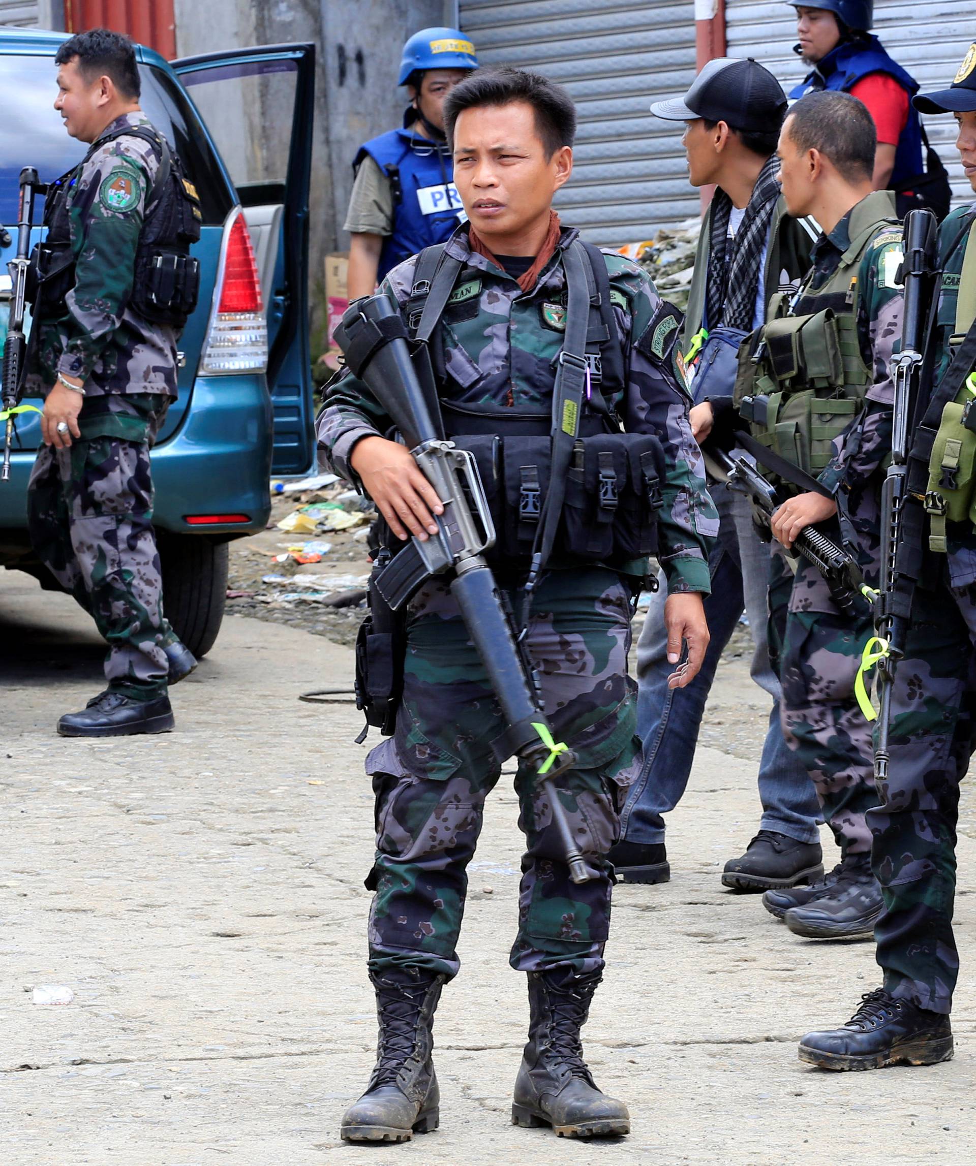 Policemen stand on guard while guarding a main street in Sarimanok village, in Marawi city