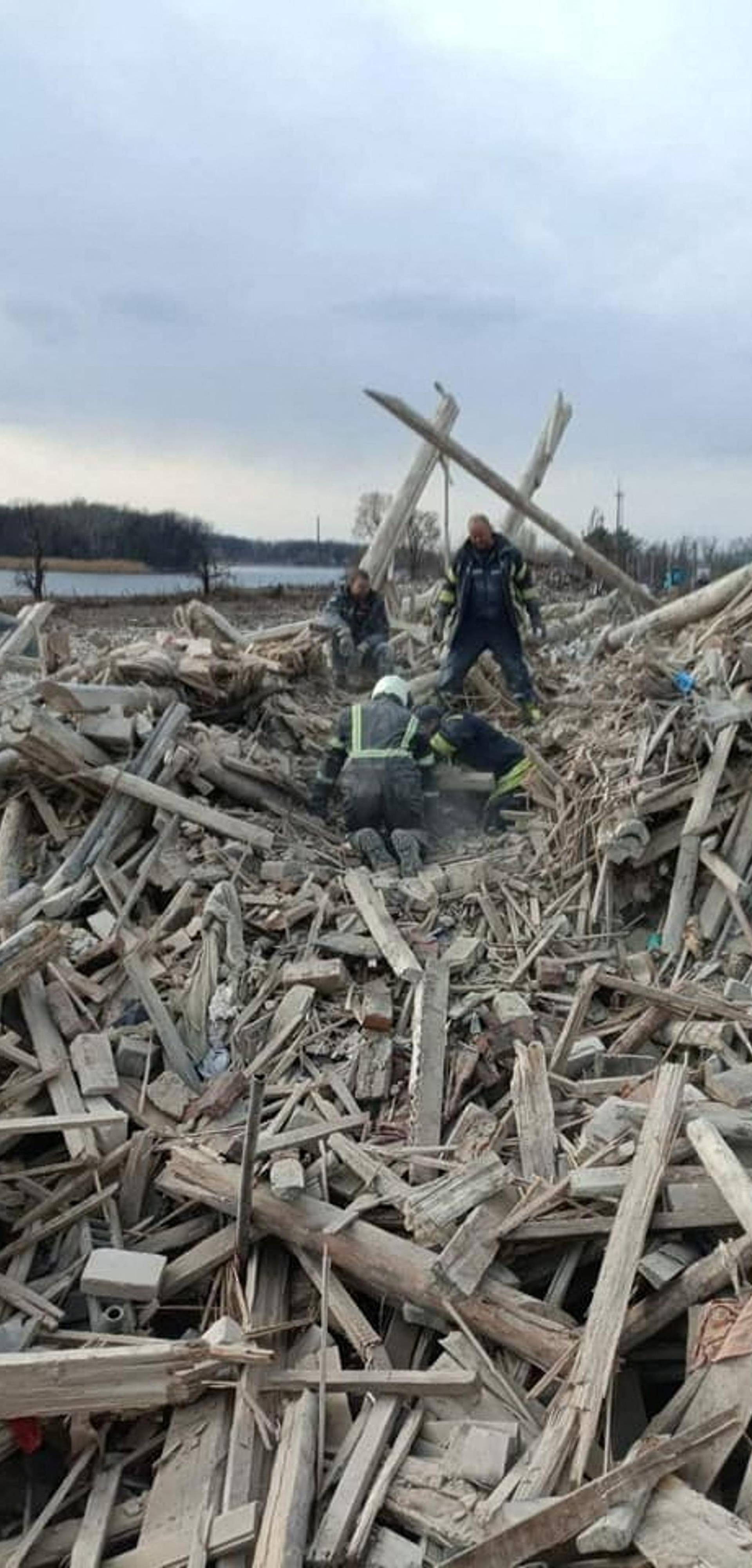 Rescuers remove a woman from debris after a military strike in Rubizhne