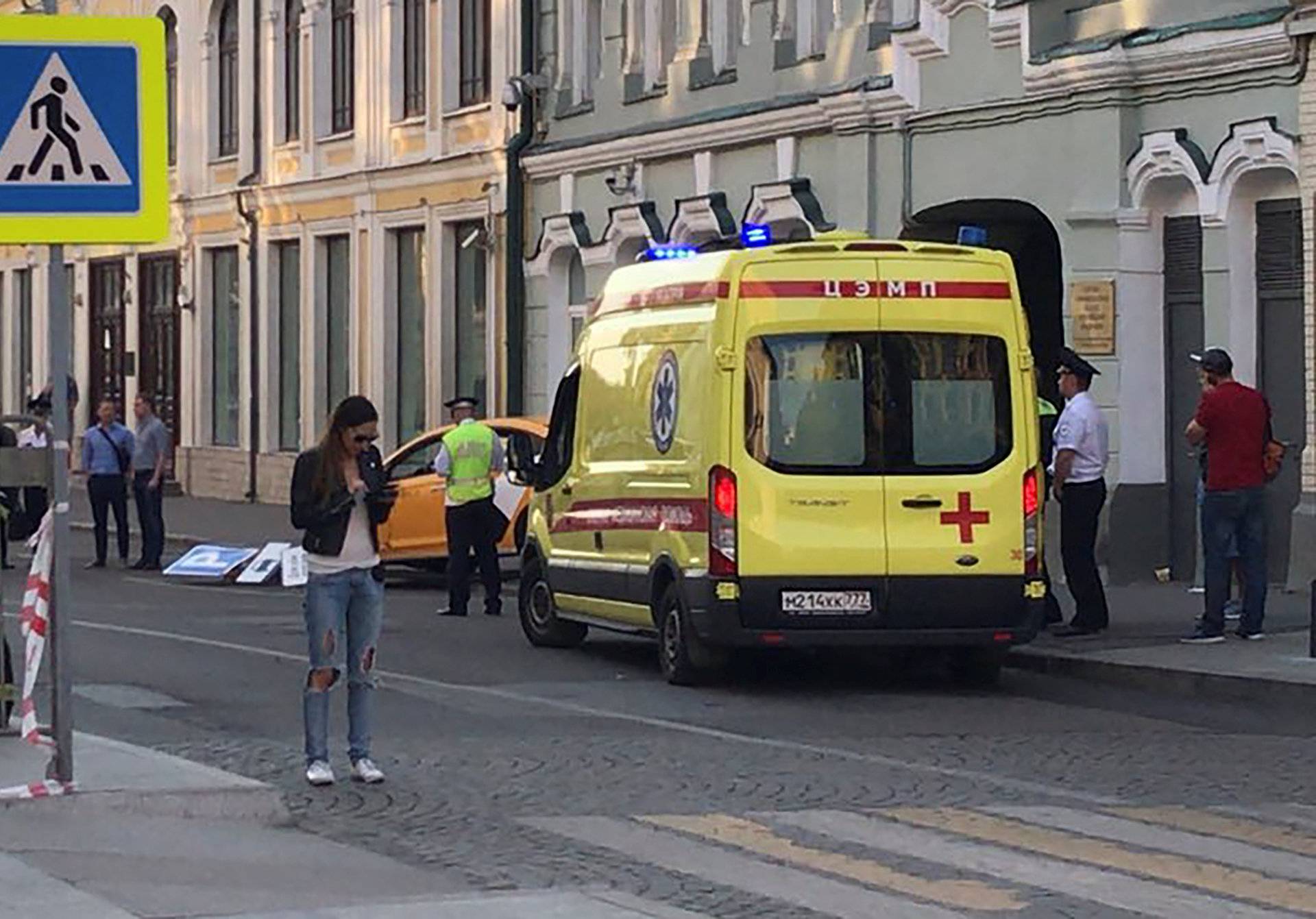 An ambulance is parked near a damaged taxi, which ran into crowds of people in central Moscow