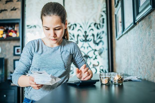 Young,Girl,Checks,Bills,In,Her,Bedroom.,There,Are,Coins